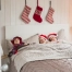 Christmas stockings on the wall above the bed of three sleeping children.