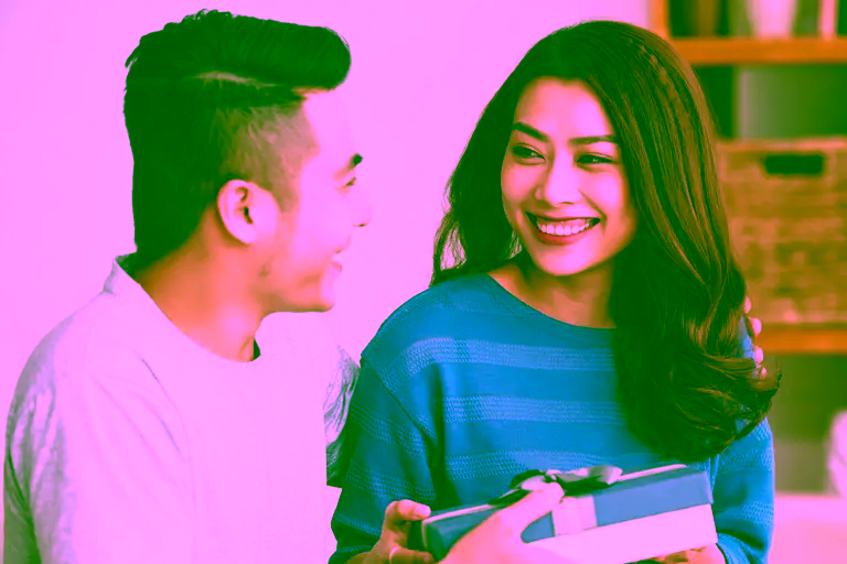 Young asian couple. Man giving his wife a gift.